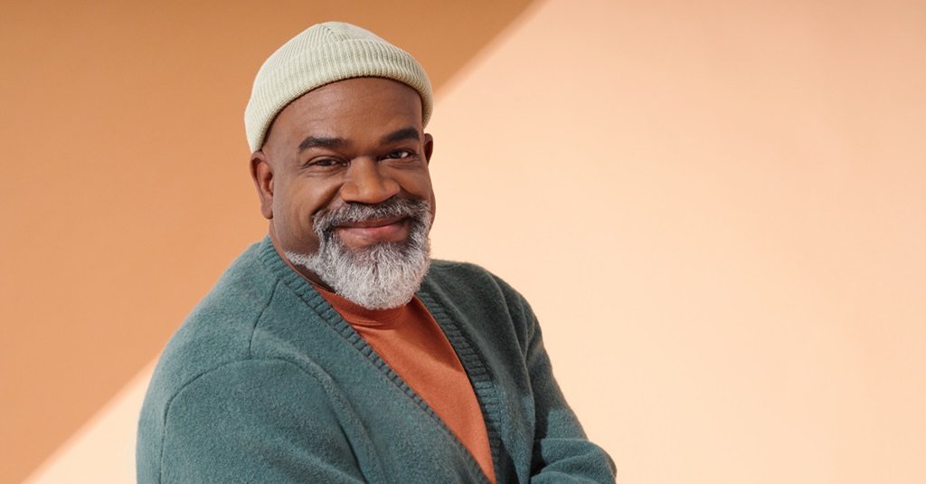 A portrait of a casually dressed man smiling.